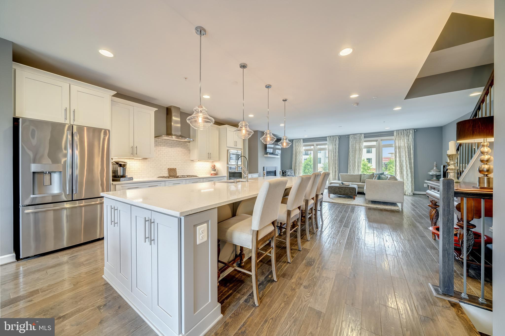 1521 Ribbon Limestone Terrace Southeast Leesburg, VA 20175 - Photo 15 of 34 a kitchen with stainless steel appliances granite countertop a refrigerator a stove top oven a dining table and chairs with wooden floor