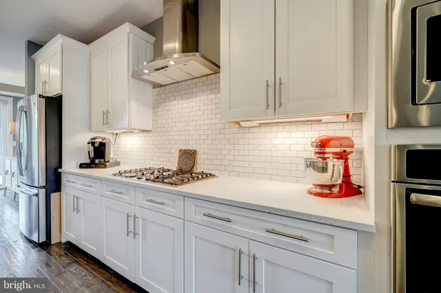 a kitchen with stainless steel appliances granite countertop a sink and a white cabinets