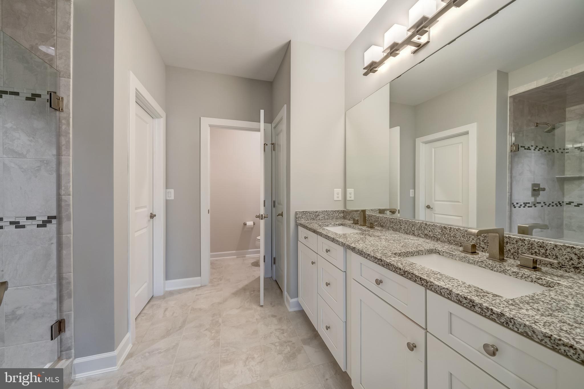 1521 Ribbon Limestone Terrace Southeast Leesburg, VA 20175 - Photo 24 of 34 a spacious bathroom with a granite countertop sink a mirror and a shower