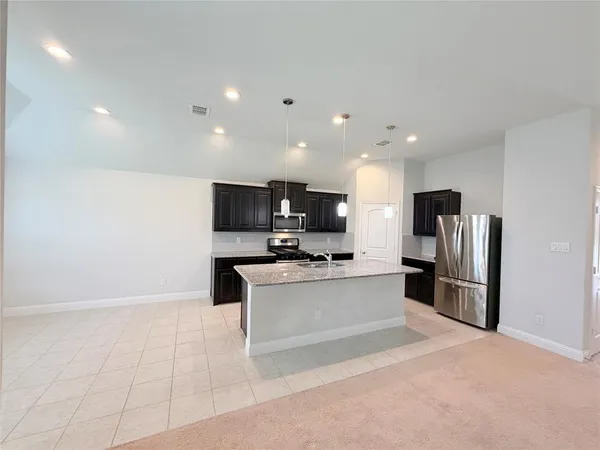 a kitchen with stainless steel appliances a refrigerator and a microwave