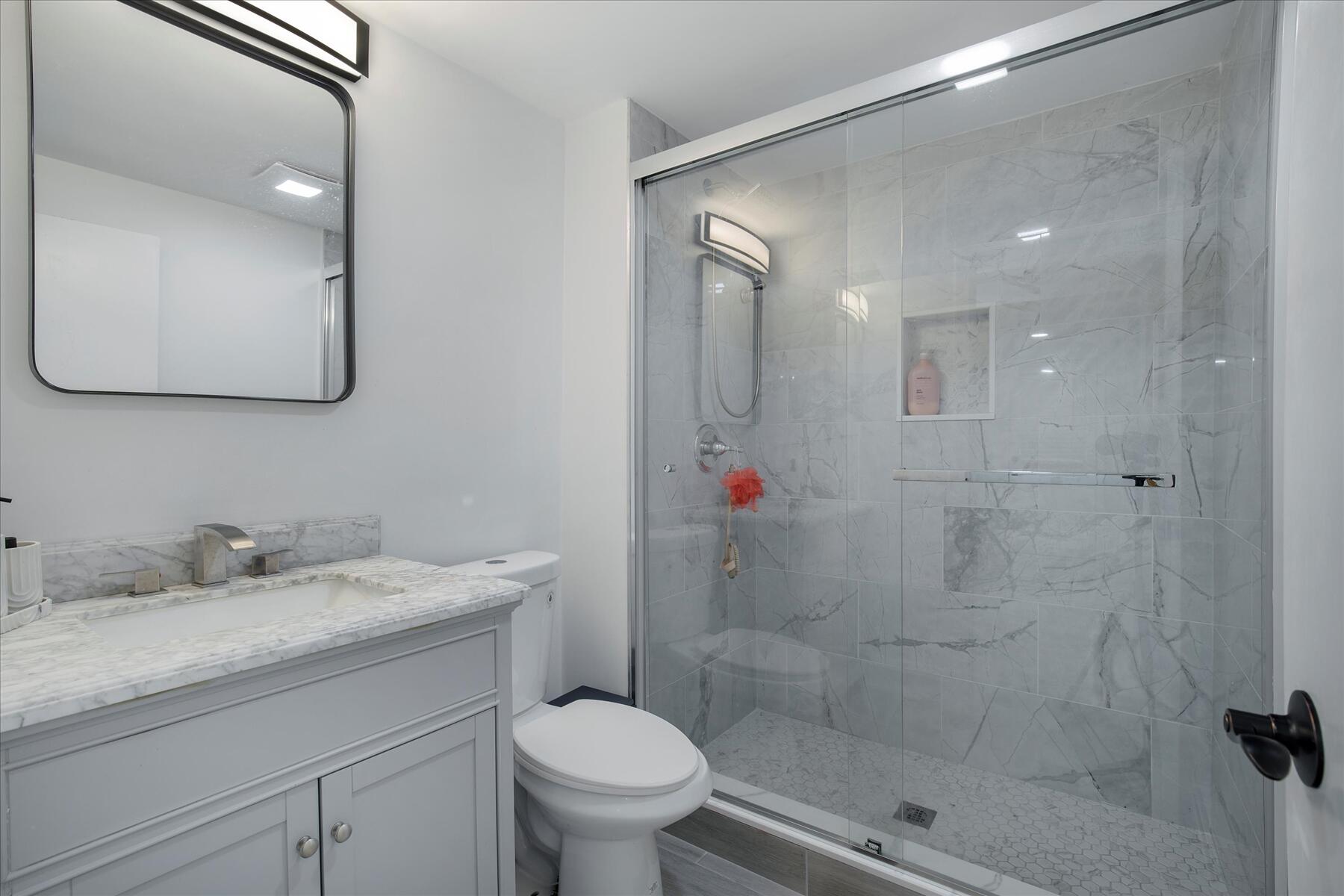 65 Marsh Lane Hyannis, MA 02601 - Photo 13 of 22 a bathroom with a shower sink vanity mirror and toilet
