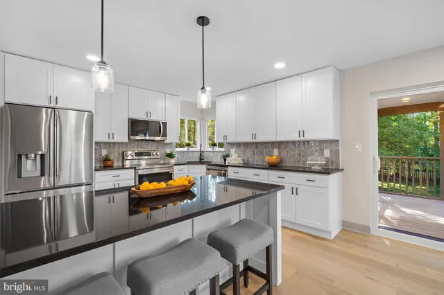 a kitchen with stainless steel appliances a stove a sink a microwave a refrigerator and cabinets