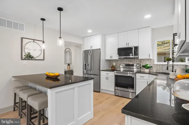 a kitchen with stainless steel appliances granite countertop a sink a stove and a refrigerator