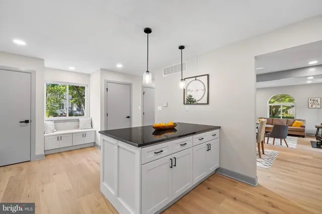 a kitchen with stainless steel appliances granite countertop a stove a sink a center island with wooden floor and cabinets