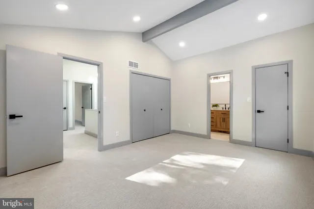 an empty room with closet and a bathroom