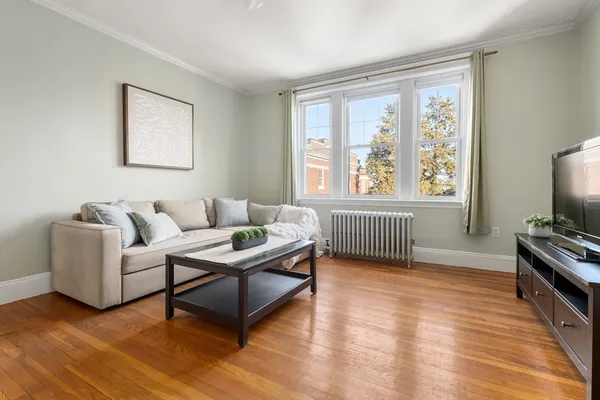a living room with furniture a flat screen tv and a window