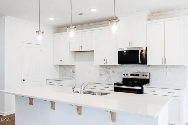 a kitchen with stainless steel appliances a sink a stove a microwave and cabinets