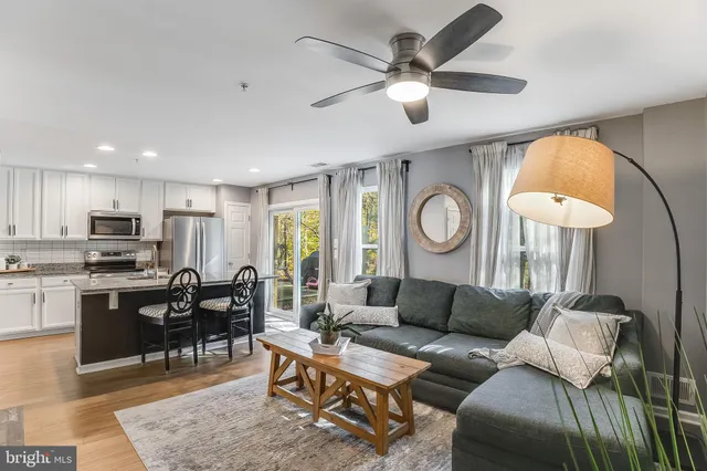 a living room with furniture a clock and a flat screen tv