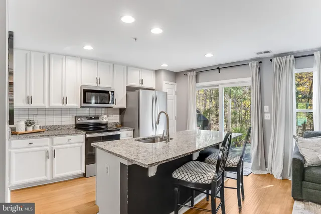 a kitchen with granite countertop white cabinets and refrigerator