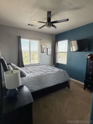 a bedroom with a bed chair and window