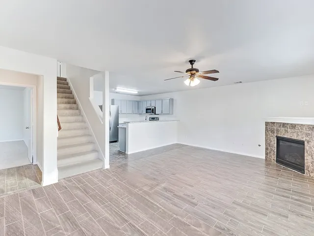 a view of a livingroom with wooden floor and a ceiling fan