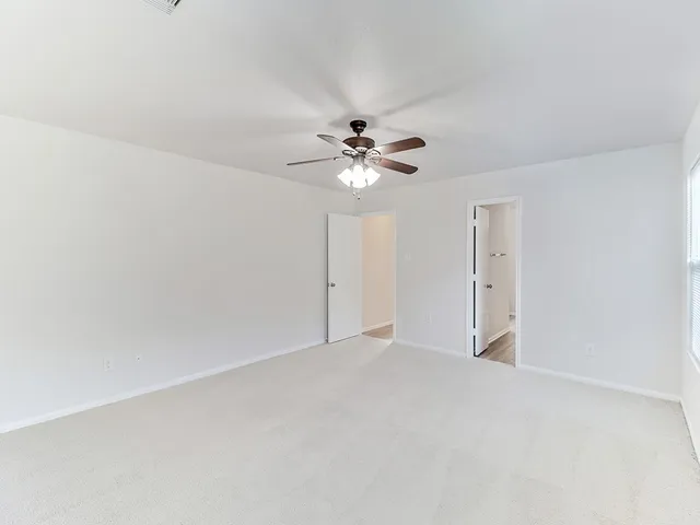 a view of an empty room with a ceiling fan