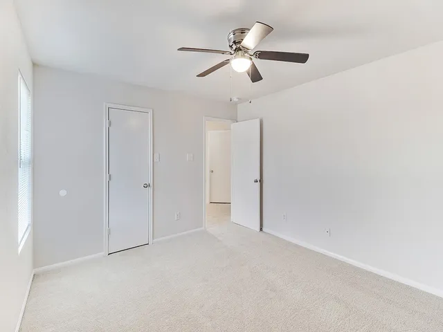 an empty room with closet and fan