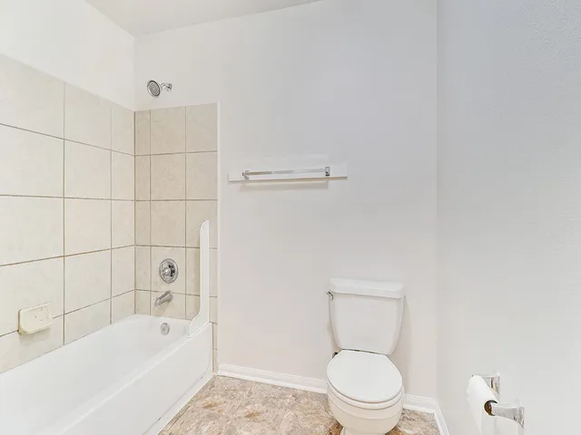 a bathroom with a toilet and a bath tub