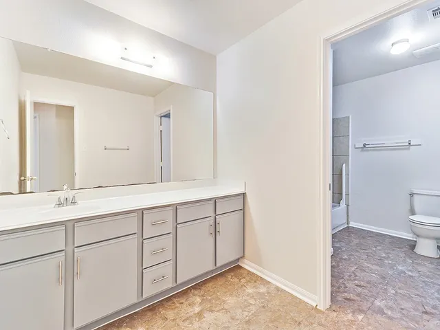 a spacious bathroom with a sink and a mirror