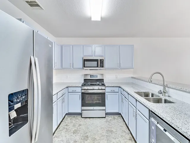 a kitchen with a sink stove and refrigerator