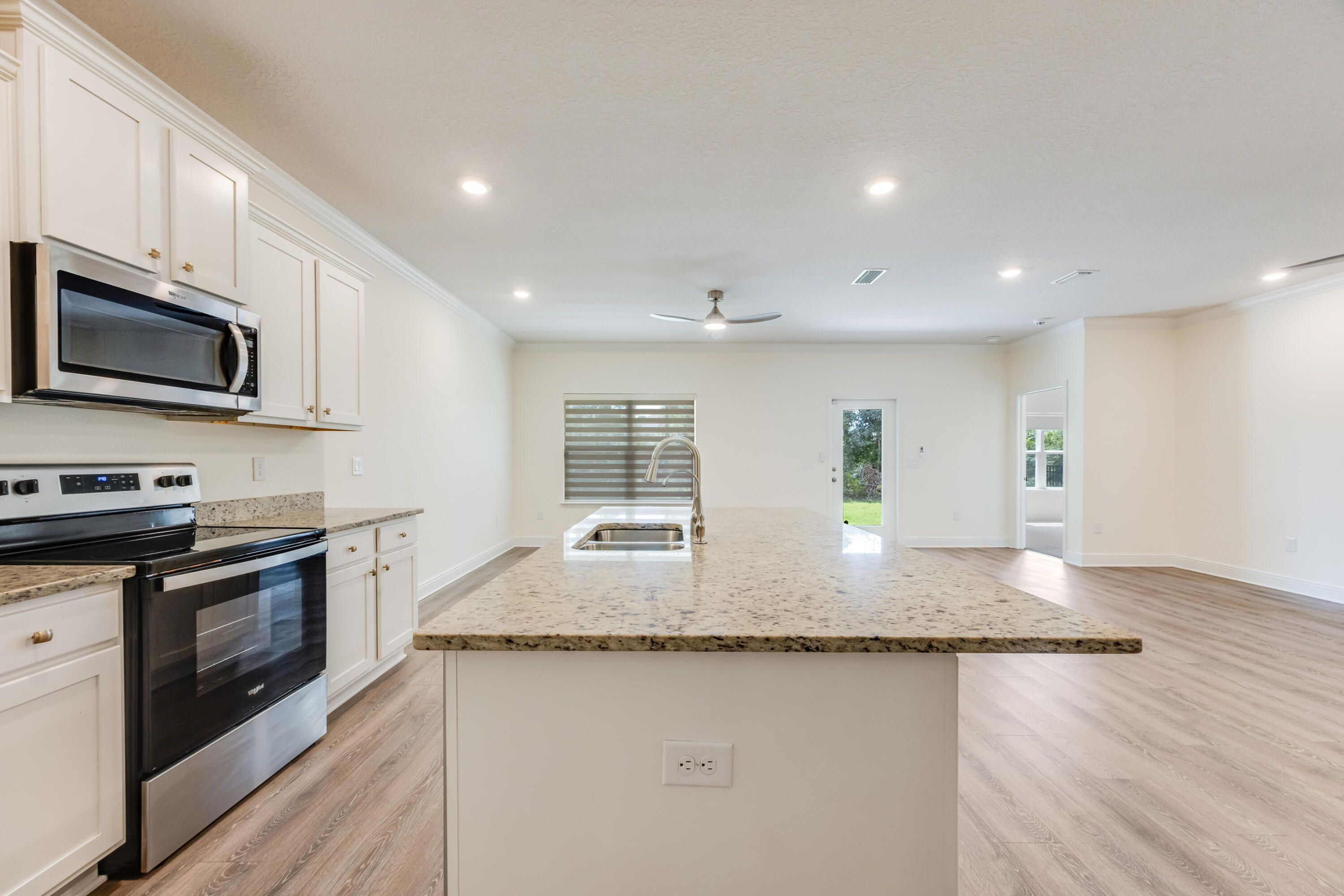 121 Lightning Bug Lane Freeport, FL 32439 - Photo 14 of 53 a kitchen with granite countertop kitchen island granite countertop wooden cabinets a stove top oven and granite counter tops
