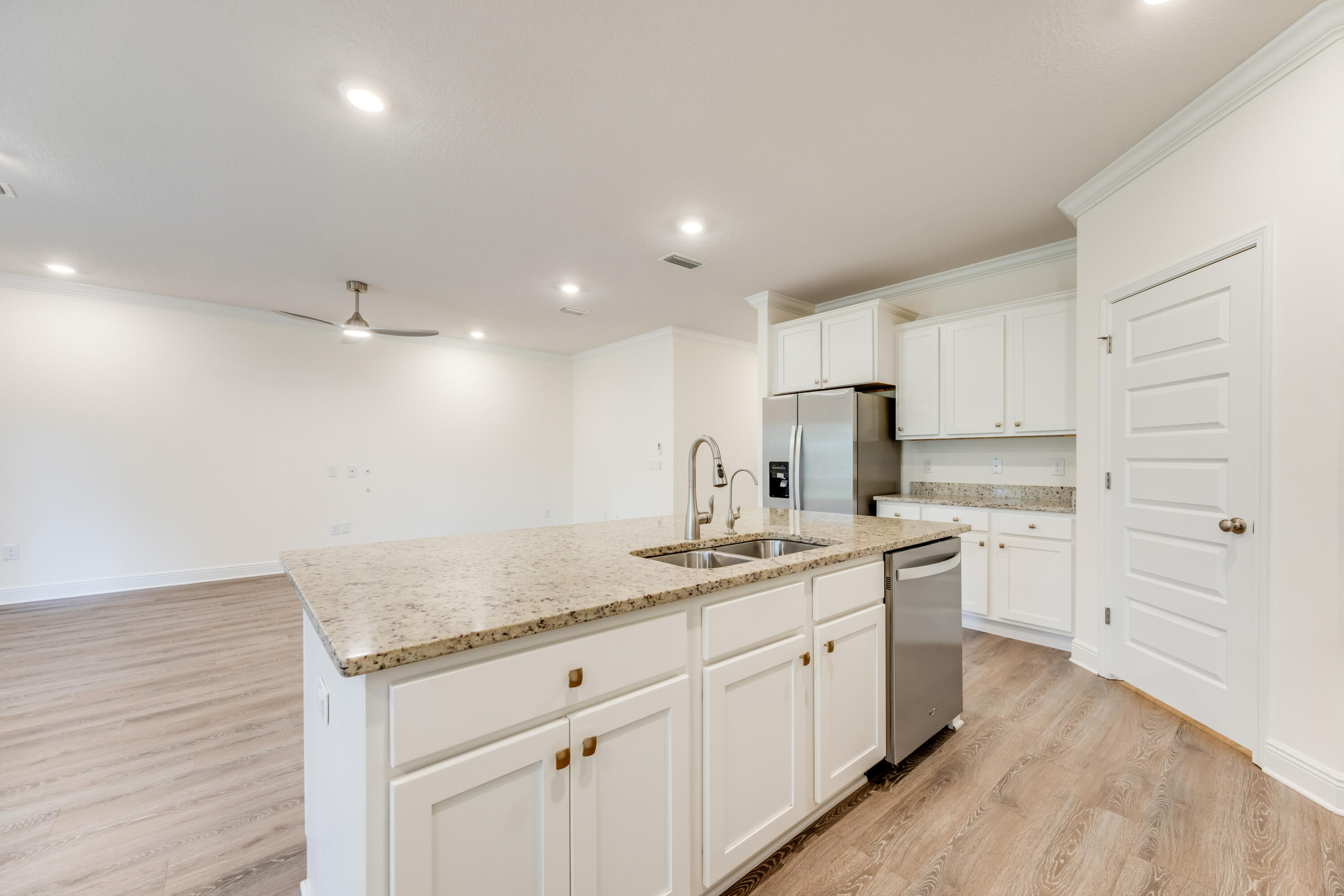 121 Lightning Bug Lane Freeport, FL 32439 - Photo 17 of 53 a kitchen with a sink dishwasher and white cabinets with wooden floor