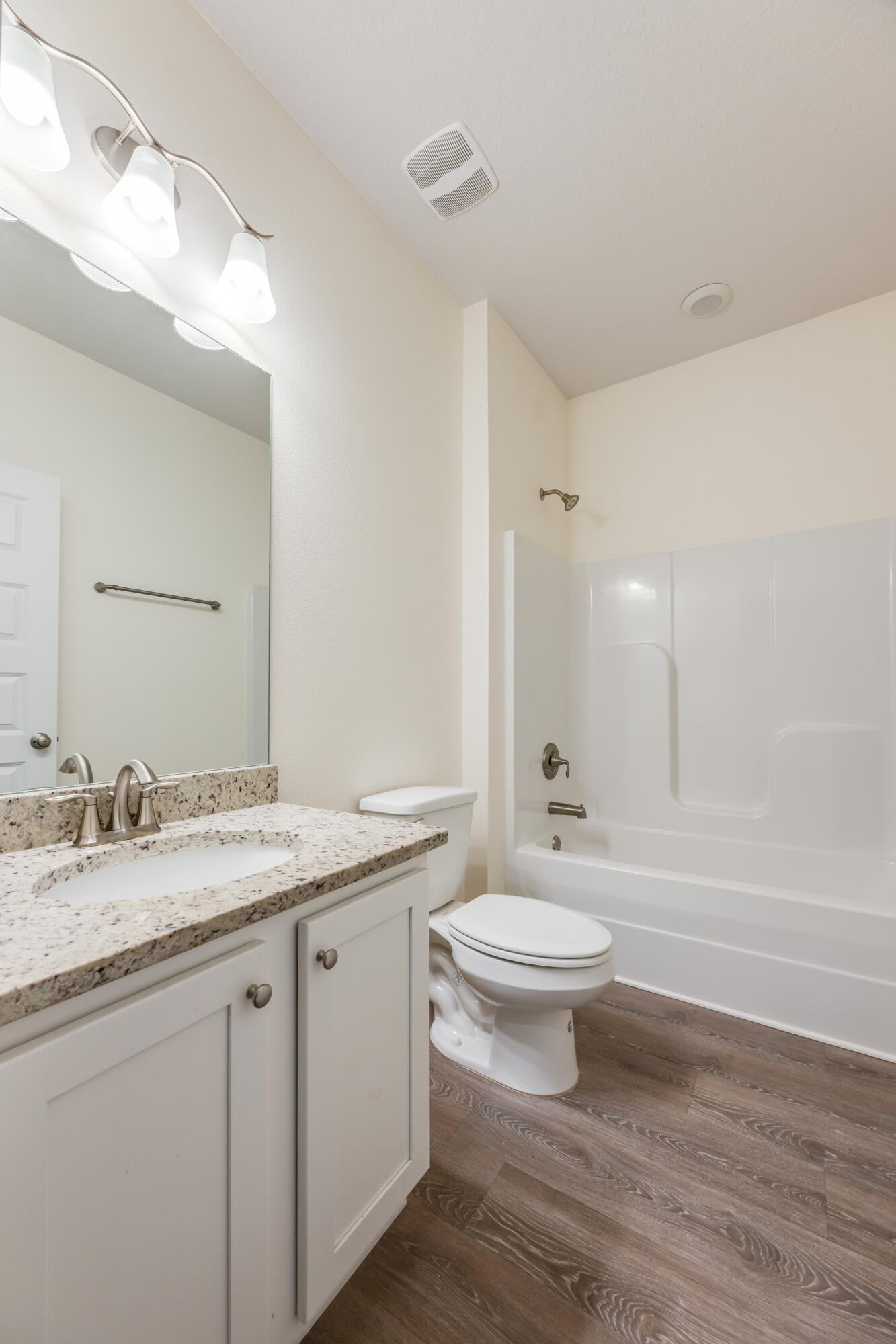 121 Lightning Bug Lane Freeport, FL 32439 - Photo 32 of 53 a bathroom with a granite countertop sink a toilet a mirror and bathtub
