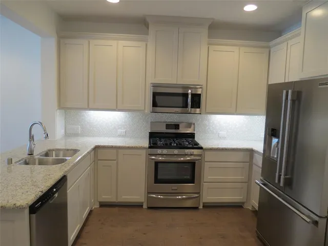 a kitchen with stainless steel appliances granite countertop a sink and a stove top oven