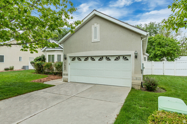 1433 Forge Way Draper, UT 84020 - Photo 2 of 29 Stucco-sided residence featuring an attached garage with decorative windows, a concrete driveway, and a manicured lawn