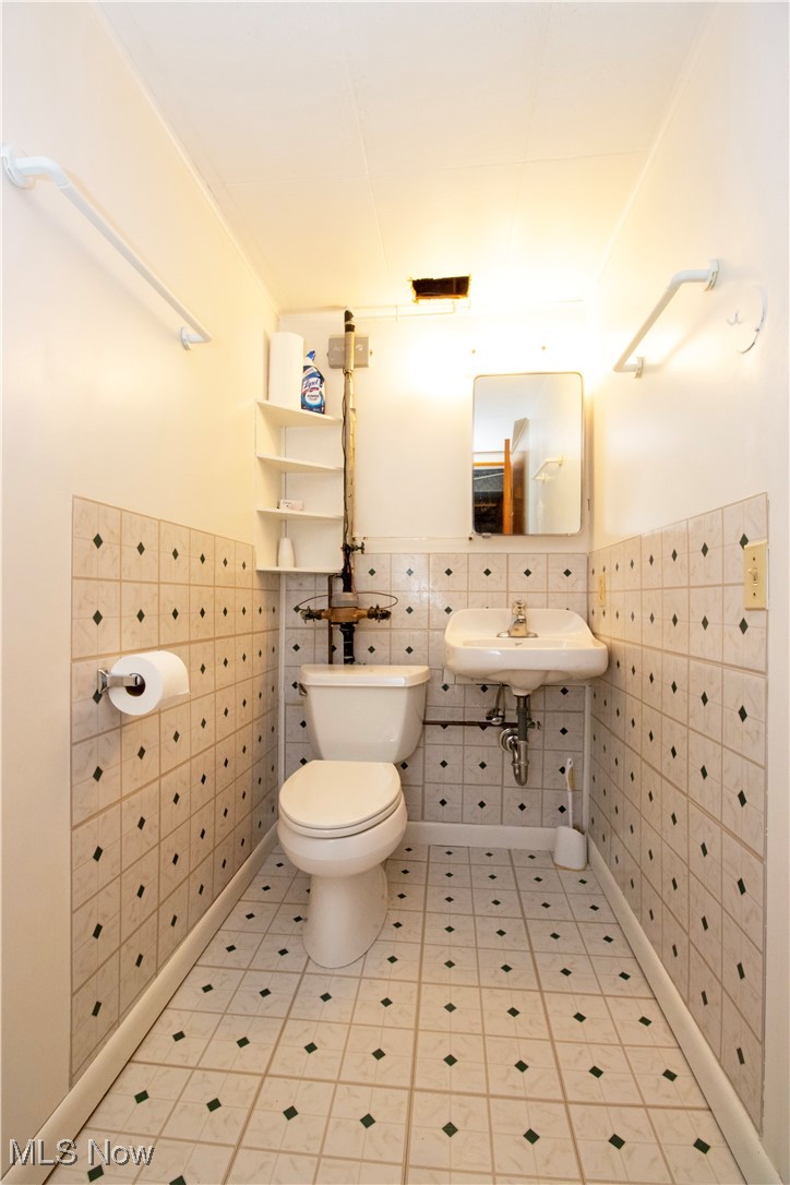 912 Ridgecrest Drive Wooster, OH 44691 - Photo 20 of 27 Bathroom with toilet, sink, and tile walls