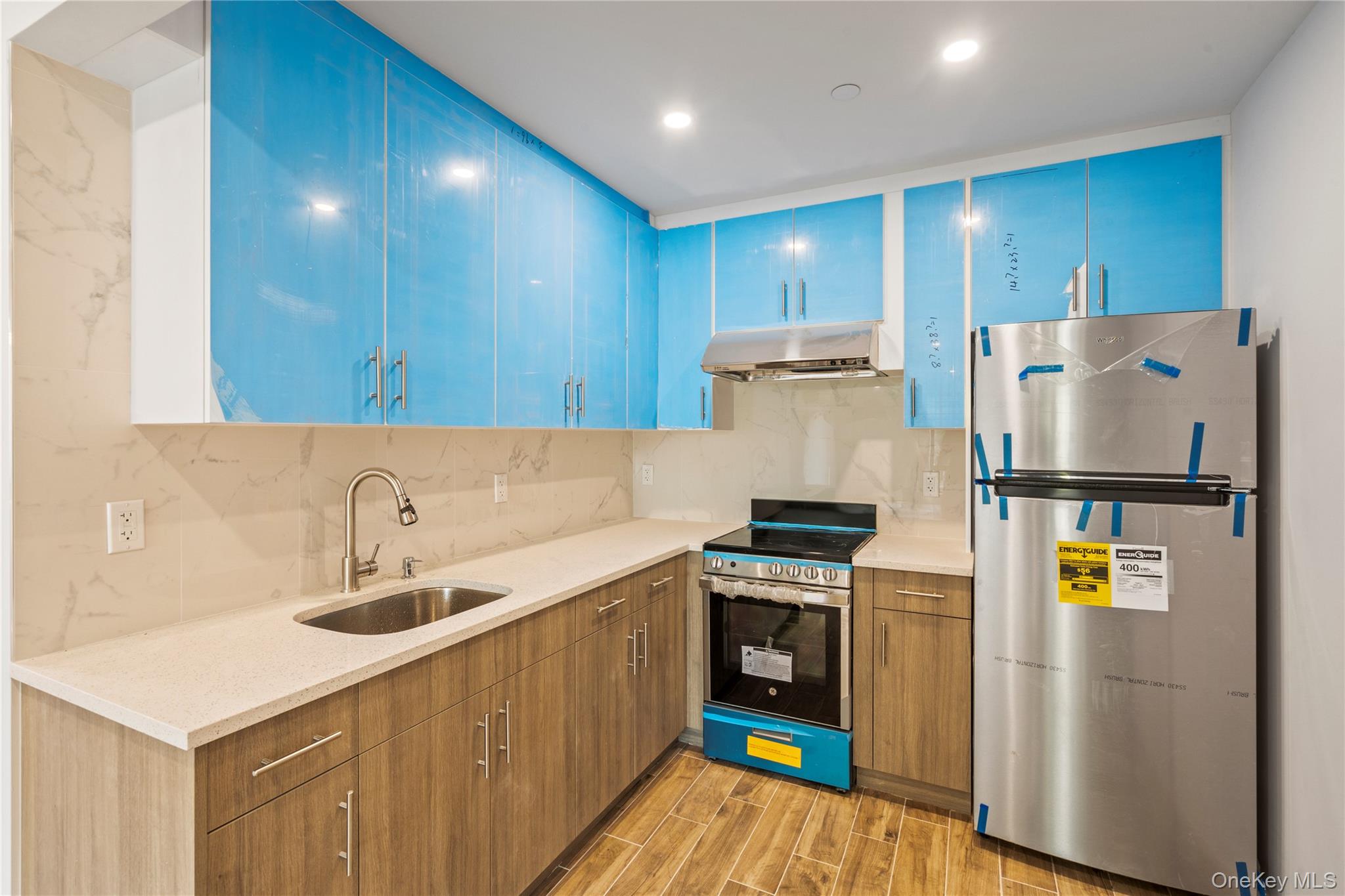 213-41 38th Avenue, Unit 2B Queens, NY 11361 - Photo 11 of 12 a kitchen with a sink a refrigerator and a stove top oven