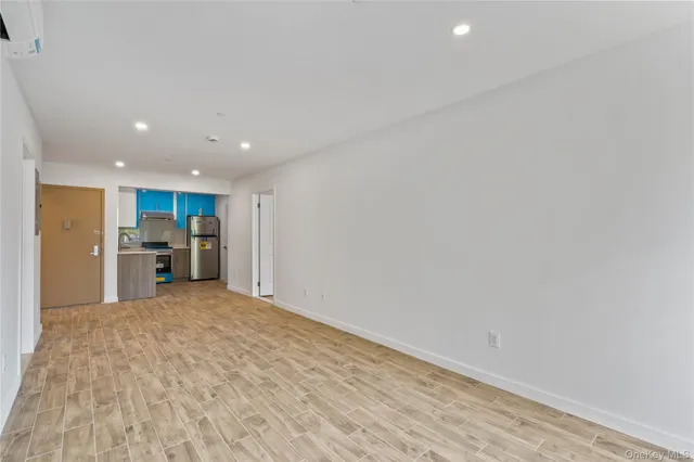 a view of a kitchen with refrigerator and wooden floor