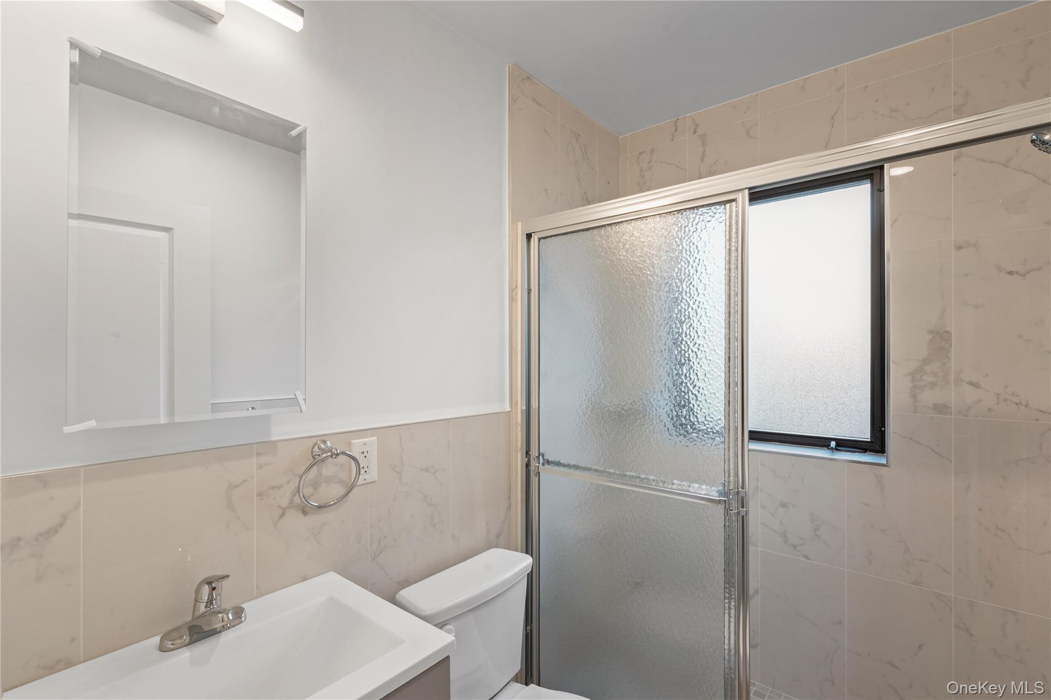 213-41 38th Avenue, Unit 2B Queens, NY 11361 - Photo 4 of 12 a bathroom with a sink and a mirror