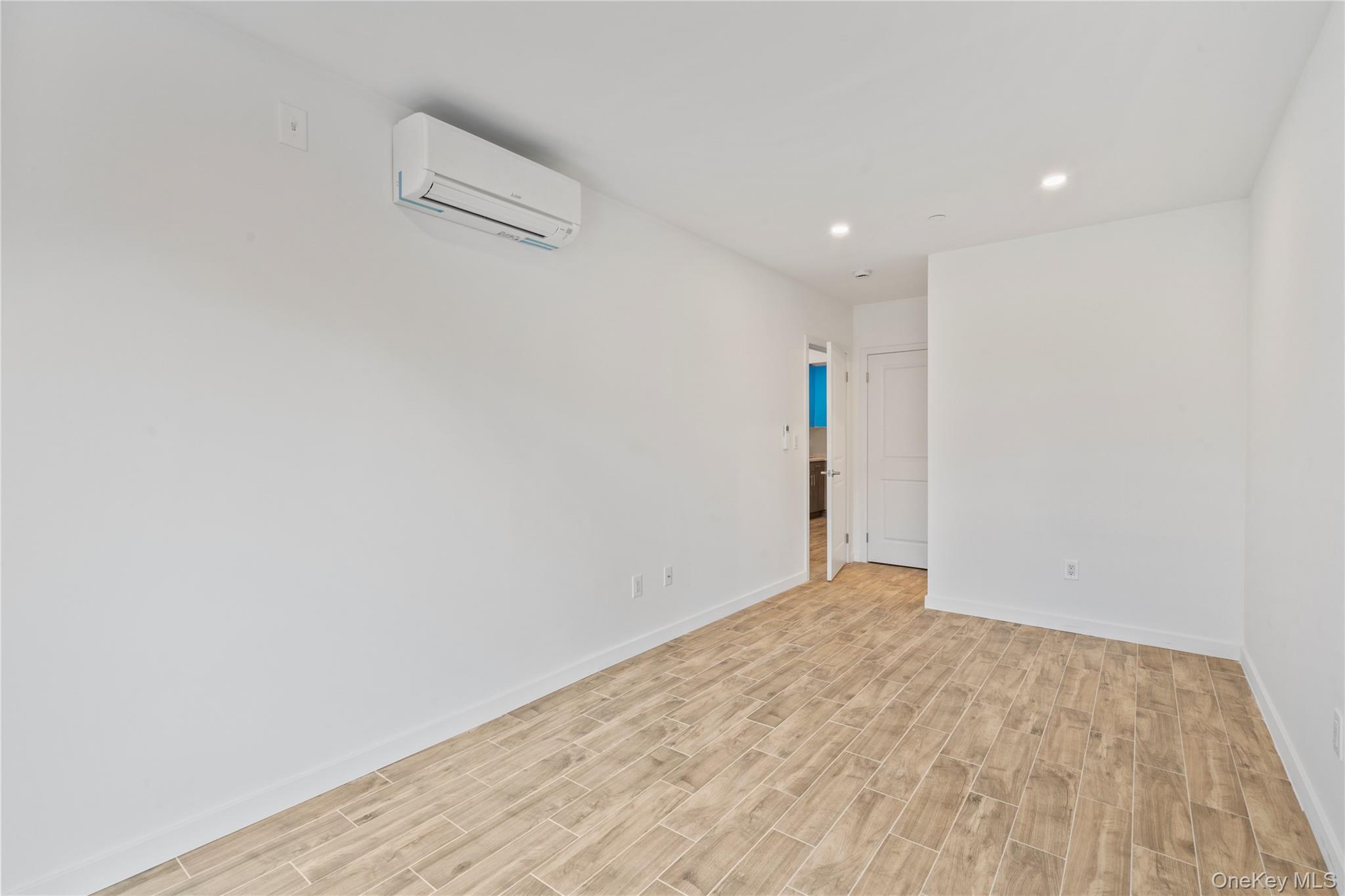 213-41 38th Avenue, Unit 2B Queens, NY 11361 - Photo 9 of 12 a view of empty room with wooden floor