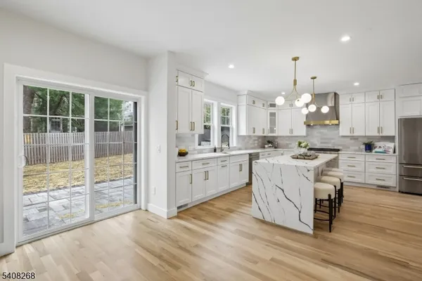 a large kitchen with kitchen island a large counter space a sink appliances and cabinets