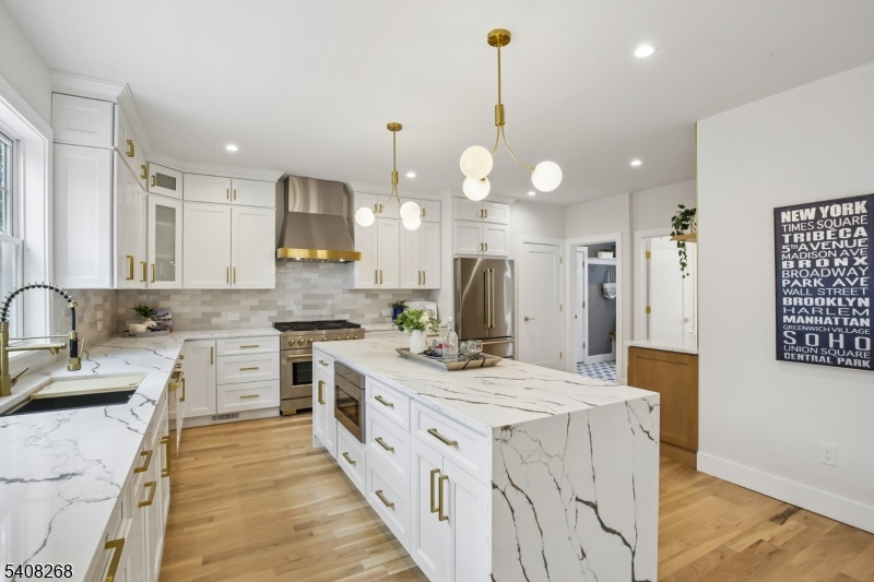 108 Baker Street Maplewood, NJ 07040 - Photo 16 of 46 a kitchen with stainless steel appliances kitchen island a sink stove cabinets and wooden floor
