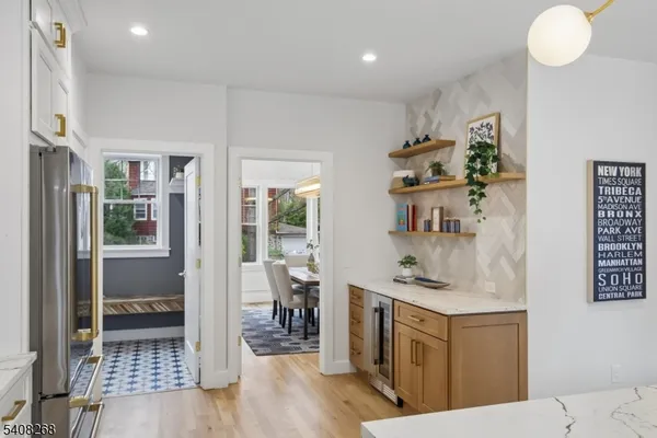 a large kitchen with stainless steel appliances kitchen island granite countertop a sink and a white cabinets