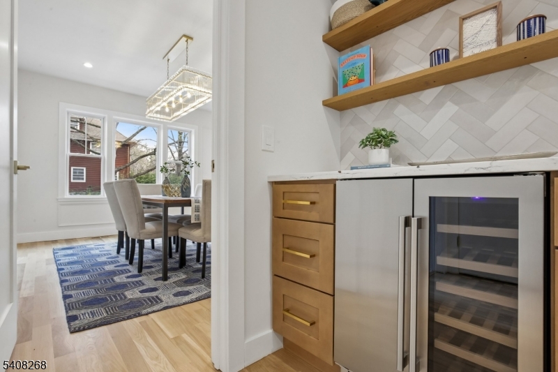 108 Baker Street Maplewood, NJ 07040 - Photo 22 of 46 a view of a dining room and livingroom with furniture wooden floor a chandelier