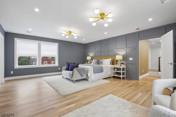 a spacious bedroom with a large bed and a chandelier