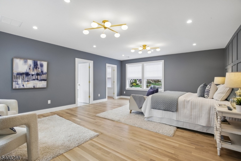 108 Baker Street Maplewood, NJ 07040 - Photo 26 of 46 a spacious bedroom with a large bed and a chandelier