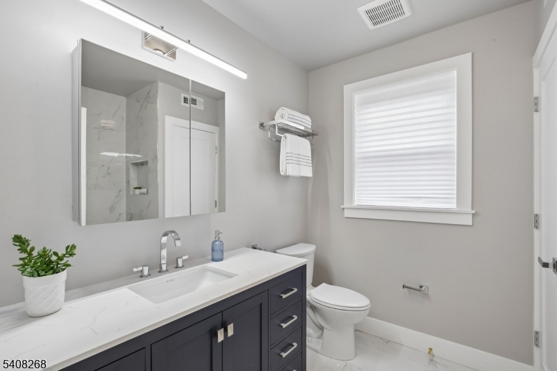 108 Baker Street Maplewood, NJ 07040 - Photo 35 of 46 a bathroom with a granite countertop sink toilet and a mirror