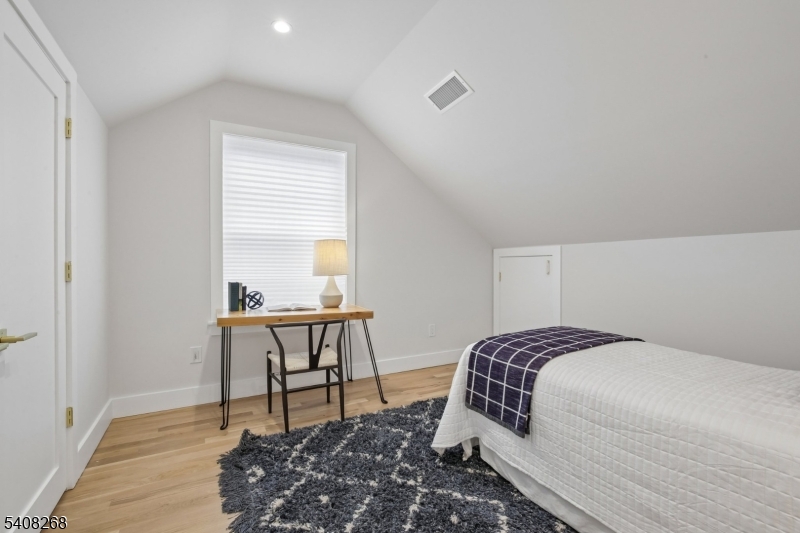 108 Baker Street Maplewood, NJ 07040 - Photo 38 of 46 a bedroom with a bed a table and a window