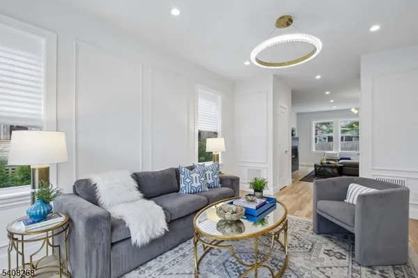 a living room with furniture and a wooden floor