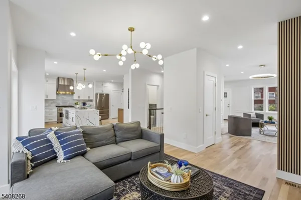 a living room with furniture and a dining table with kitchen view