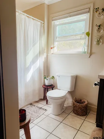 a bathroom with a toilet and a window