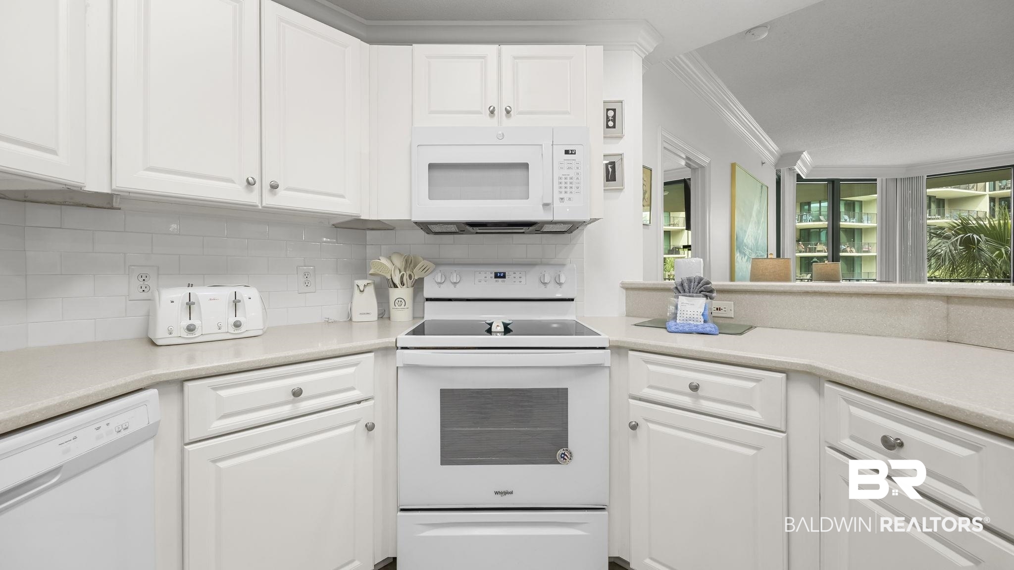 27580 Canal Road, Unit 1213 Orange Beach, AL 36561 - Photo 7 of 27 White kitchen featuring white cabinetry, light countertops, subway tile backsplash, a built-in microwave, and a smooth-top electric range