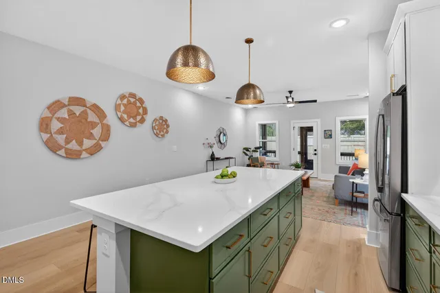 a kitchen with stainless steel appliances granite countertop a refrigerator a sink a stove a dining table and chairs