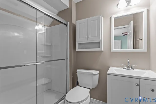 a bathroom with a toilet sink vanity and granite