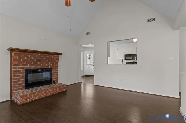 a view of a livingroom with wooden floor and a fireplace