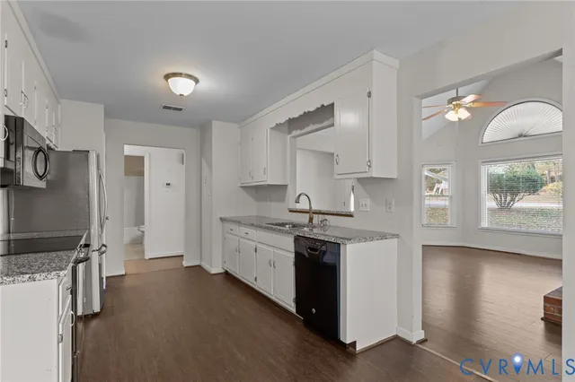 a large kitchen with stainless steel appliances a sink stove and cabinets