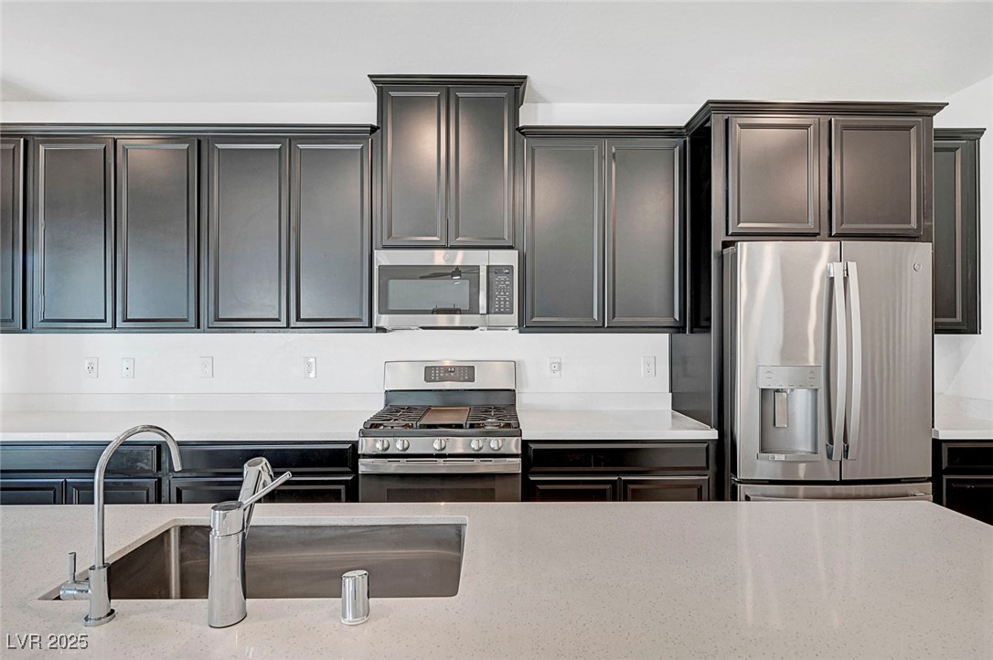 7204 North Decatur Boulevard North Las Vegas, NV 89084 - Photo 25 of 55 Kitchen with a sink, appliances with stainless steel finishes, and light stone countertops