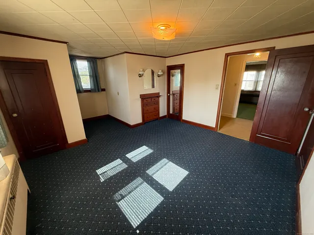 a view of an empty room with a fireplace and a window