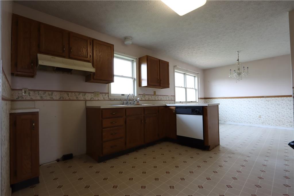 370 Pfeifer Road Harmony, PA 16037 - Photo 4 of 35 a kitchen with granite countertop a refrigerator and a stove top oven