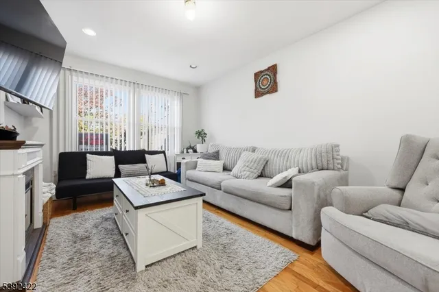a living room with furniture a flat screen tv and a window